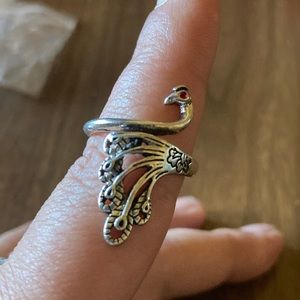 Silver toned peacock ring with red eye.